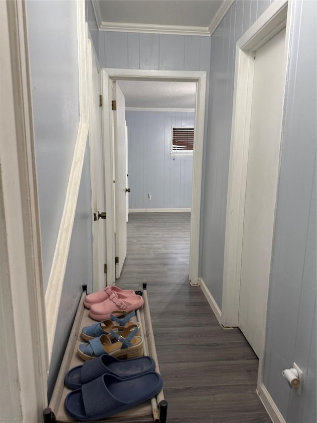 corridor featuring baseboards, wood finished floors, crown molding, and a wall mounted AC