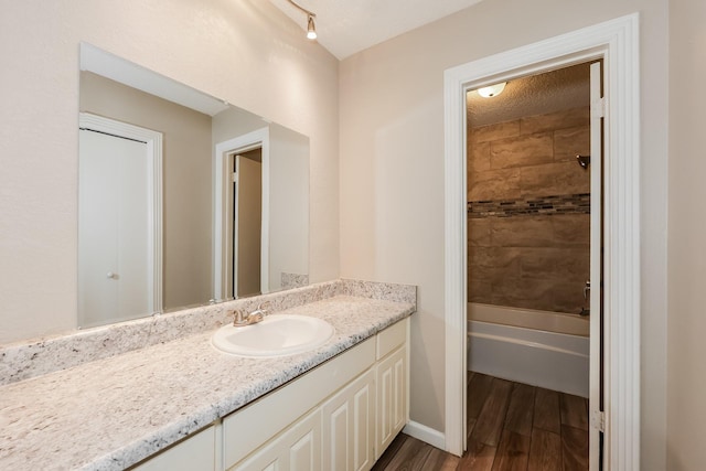 full bathroom with bathing tub / shower combination, vanity, and wood finished floors