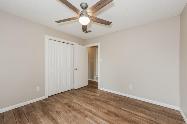 unfurnished bedroom with visible vents, baseboards, and wood finished floors