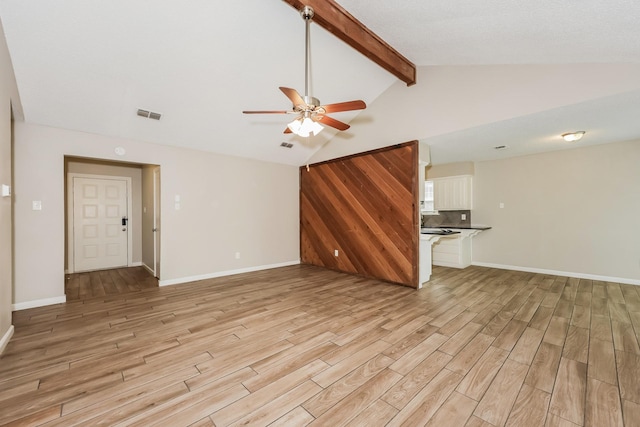 unfurnished living room with visible vents, ceiling fan, light wood finished floors, and lofted ceiling with beams