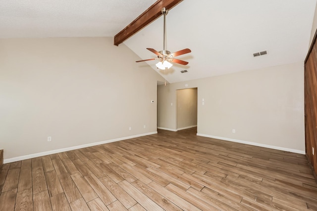 spare room featuring light wood finished floors, ceiling fan, vaulted ceiling with beams, and visible vents