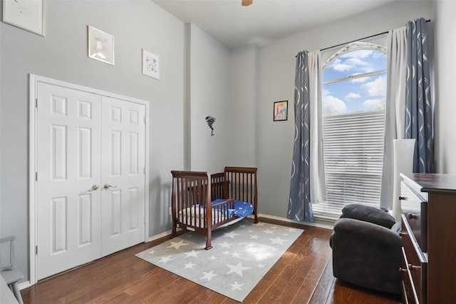 805 Red Oak Ct, Crowley, TX 76036 - bedroom featuring dark wood finished floors, a crib, baseboards, and a closet
