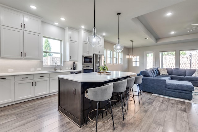 3128 Lexington Dr, Celina, TX 75009 - kitchen featuring stainless steel appliances, open floor plan, a kitchen island, light wood-style flooring, and a kitchen breakfast bar