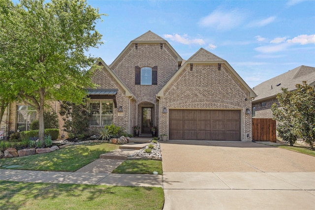french country inspired facade featuring a front lawn, brick siding, an attached garage, a shingled roof, and driveway