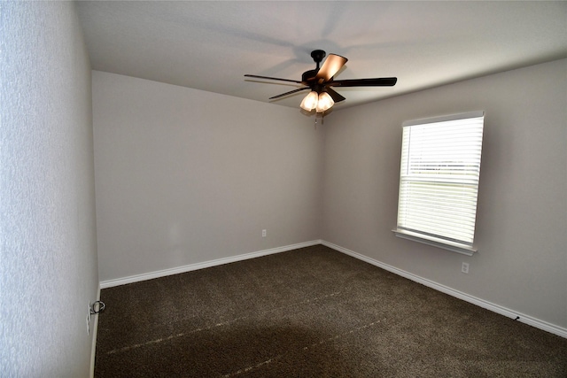 unfurnished room with dark colored carpet, a ceiling fan, and baseboards