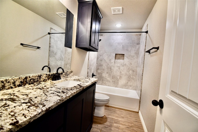 bathroom featuring a textured ceiling, vanity, toilet, wood finished floors, and baseboards