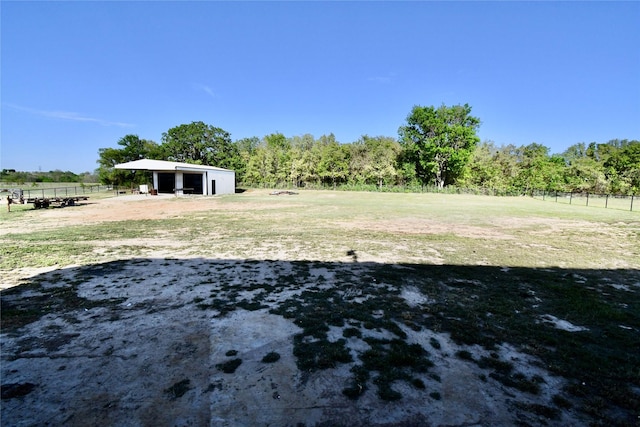 view of yard with a garage, fence, and an outdoor structure