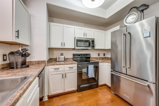 330 Las Colinas Blvd E Unit 364, Irving, TX 75039 - kitchen featuring appliances with stainless steel finishes, light wood-style floors, white cabinets, and light countertops