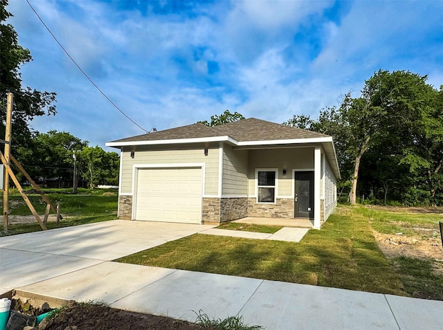 409 S Main St, Bonham, TX 75418 - view of front of property featuring a garage, driveway, stone siding, and a front lawn