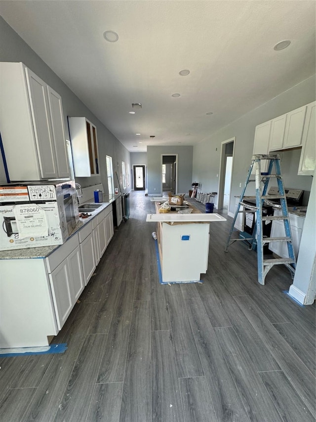 409 S Main St, Bonham, TX 75418 - kitchen with a sink, dark wood-style floors, white cabinets, a center island, and open floor plan