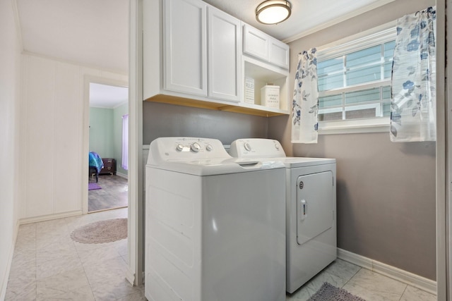 laundry room featuring baseboards, ornamental molding, independent washer and dryer, cabinet space, and marble finish floor