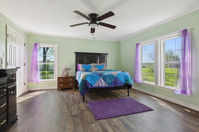 bedroom featuring crown molding, baseboards, ceiling fan, and dark wood finished floors
