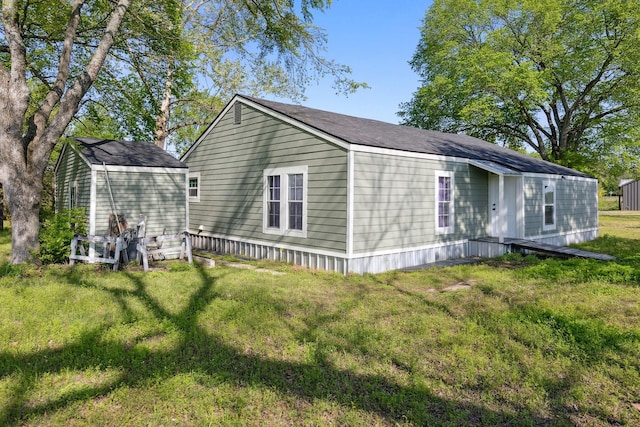 view of side of home with a shed, an outbuilding, and a lawn
