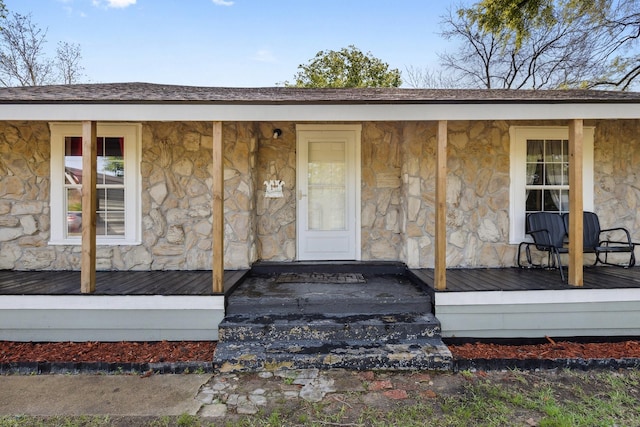 property entrance with stone siding and covered porch