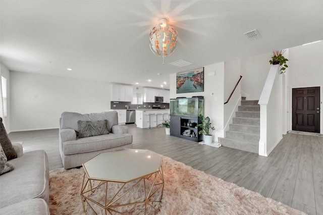 1335 Panorama Dr, Forney, TX 75126 - living room with light wood finished floors, visible vents, and stairs
