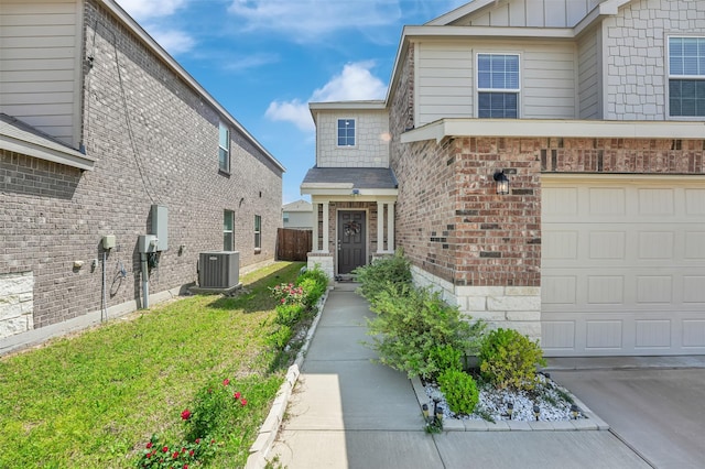 1335 Panorama Dr, Forney, TX 75126 - view of front of property with board and batten siding, a front lawn, brick siding, an attached garage, and central AC unit