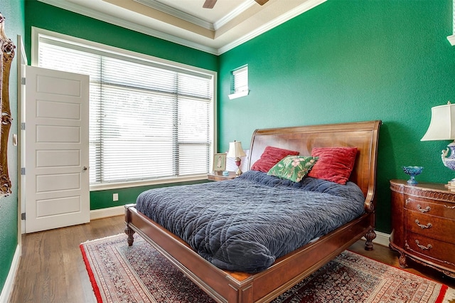 bedroom with a ceiling fan, baseboards, ornamental molding, and wood finished floors