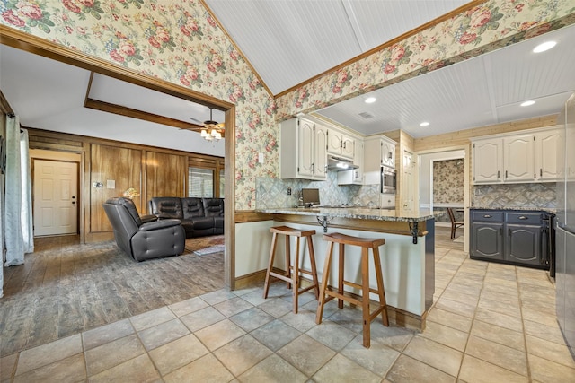 6 Broadmoor Way, Lucas, TX 75098 - kitchen with under cabinet range hood, a peninsula, stainless steel microwave, decorative backsplash, and wallpapered walls