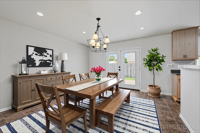 dining room featuring french doors, dark tile patterned floors, baseboards, and a notable chandelier