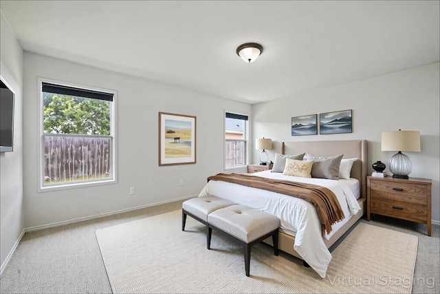 bedroom featuring carpet flooring, baseboards, and multiple windows