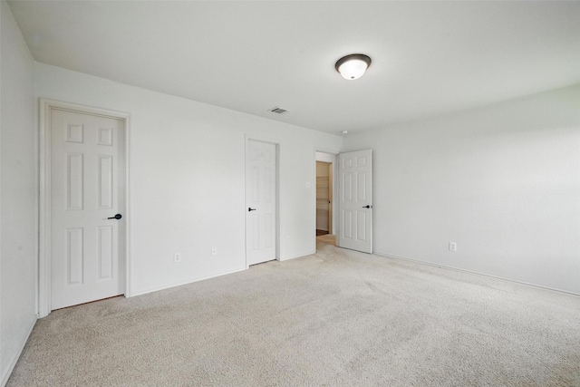 unfurnished bedroom with visible vents, baseboards, and light carpet