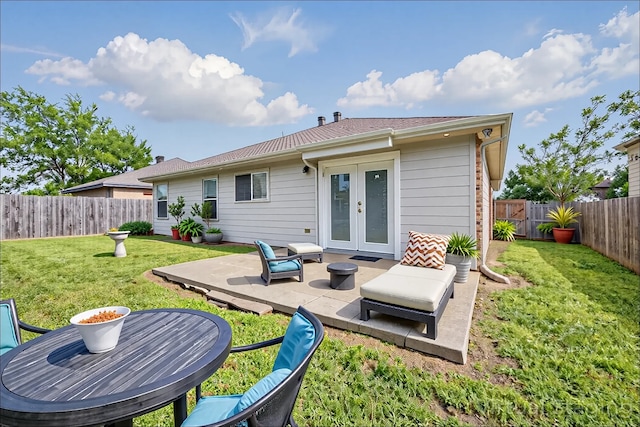 back of property with a patio, a fenced backyard, a lawn, and french doors