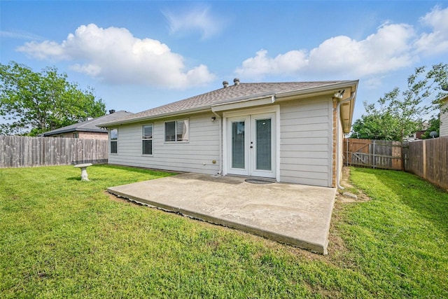 rear view of property featuring french doors, a fenced backyard, a yard, and a patio area