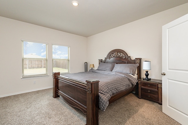 bedroom with baseboards and light colored carpet