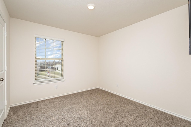 carpeted empty room with baseboards