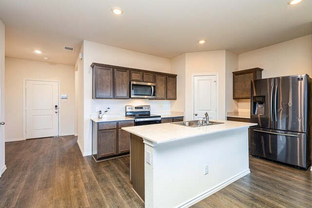 kitchen featuring stainless steel appliances, a sink, dark wood-style flooring, dark brown cabinetry, and light countertops