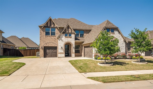 1314 Middleton Dr, Rockwall, TX 75087 - tudor-style house featuring fence, a front lawn, concrete driveway, brick siding, and a garage