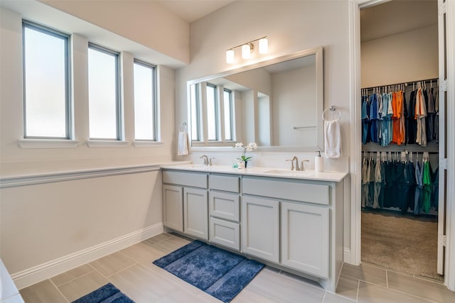 1314 Middleton Dr, Rockwall, TX 75087 - bathroom featuring double vanity, a sink, a spacious closet, and baseboards
