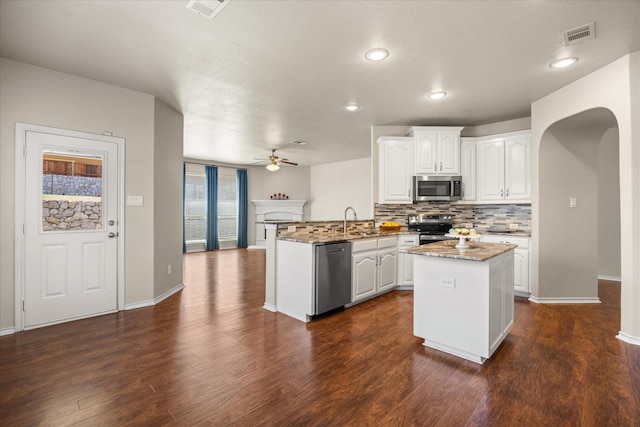 1509 Salado Trl, Weatherford, TX 76087 - kitchen featuring visible vents, a peninsula, ceiling fan, arched walkways, and appliances with stainless steel finishes