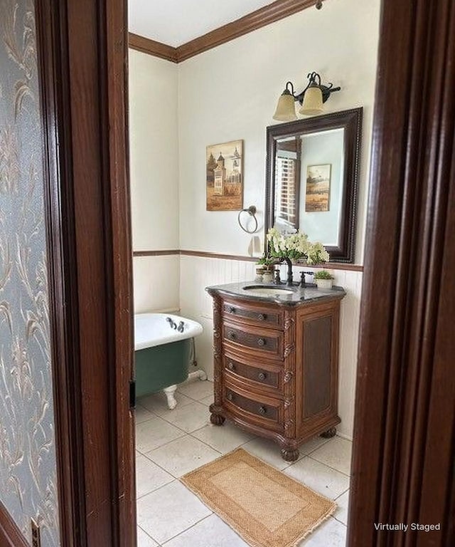 bathroom featuring crown molding, a soaking tub, tile patterned floors, and a wainscoted wall