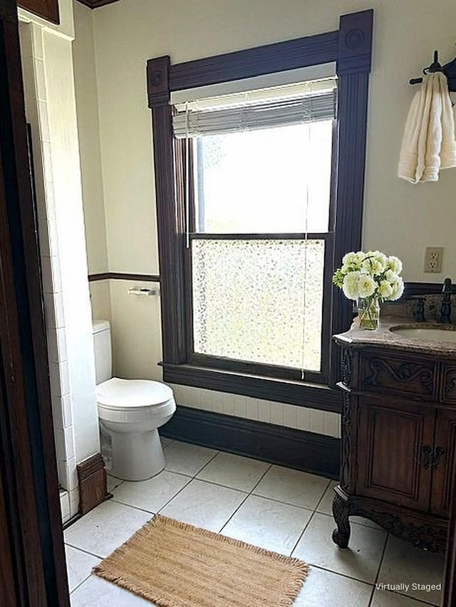 bathroom featuring tile patterned flooring, toilet, and vanity