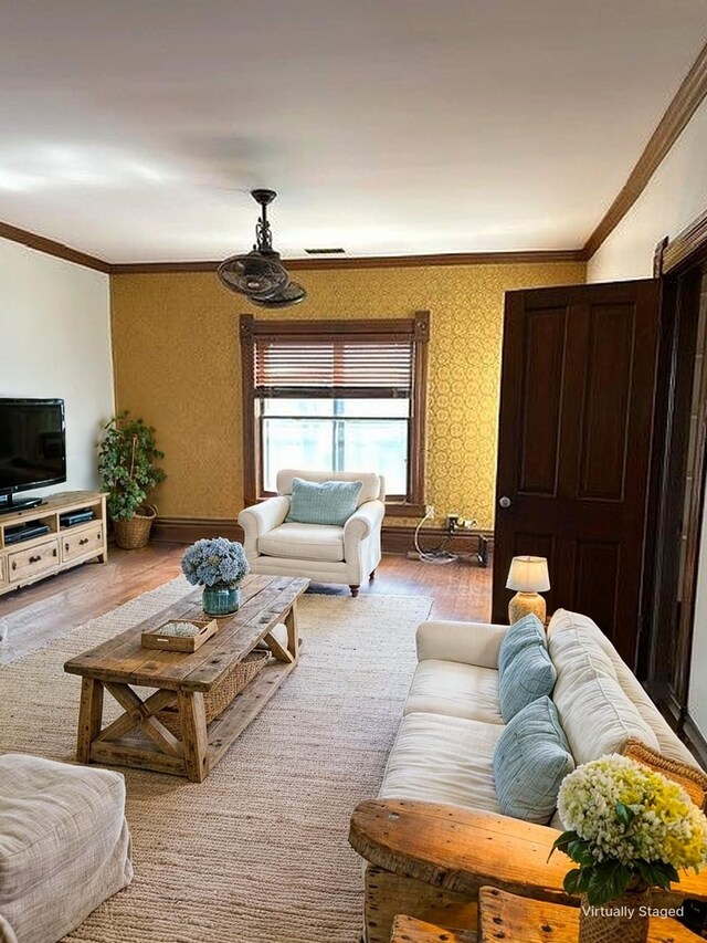 living room with baseboards, ornamental molding, wood finished floors, and wallpapered walls