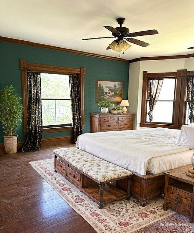 bedroom with crown molding, wood finished floors, and multiple windows
