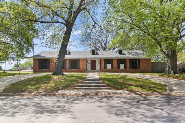 800 Western Hills Dr, Sherman, TX 75092 - ranch-style house featuring brick siding, curved driveway, fence, and a front lawn