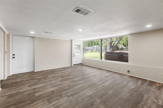 800 Western Hills Dr, Sherman, TX 75092 - empty room with a textured ceiling, brick wall, wood finished floors, and visible vents