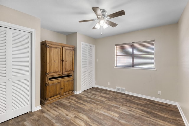 800 Western Hills Dr, Sherman, TX 75092 - unfurnished bedroom with visible vents, baseboards, two closets, and dark wood finished floors