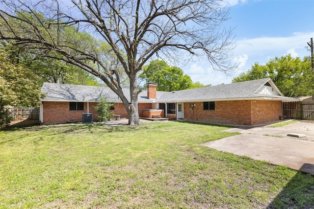 800 Western Hills Dr, Sherman, TX 75092 - back of property with a hot tub, cooling unit, fence, brick siding, and a chimney
