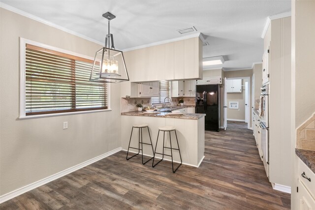 800 Western Hills Dr, Sherman, TX 75092 - kitchen featuring black fridge, a peninsula, a sink, and ornamental molding