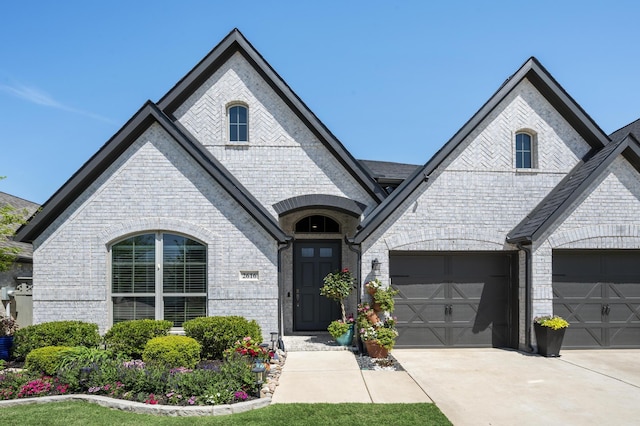 french provincial home with brick siding and driveway
