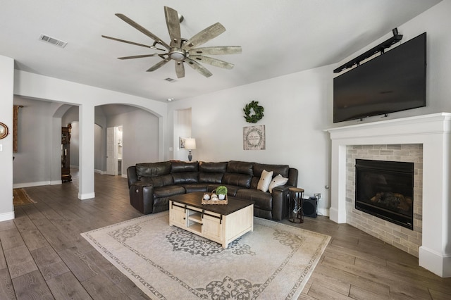 2616 Lazy Dog Ln, Northlake, TX 76247 - living room with arched walkways, a ceiling fan, wood finished floors, a brick fireplace, and baseboards
