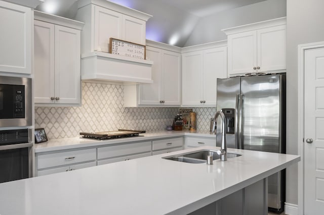 kitchen with stainless steel appliances, light countertops, a sink, and backsplash