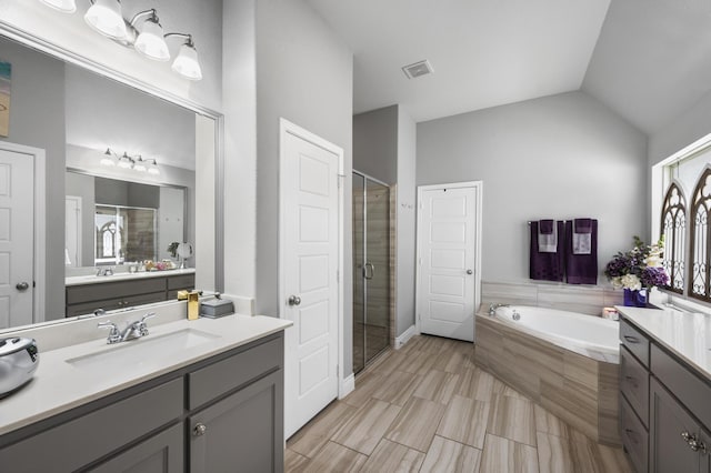full bath featuring visible vents, a shower stall, vaulted ceiling, and a garden tub