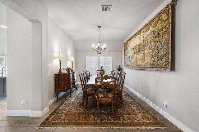 dining area with a wealth of natural light, visible vents, baseboards, and an inviting chandelier