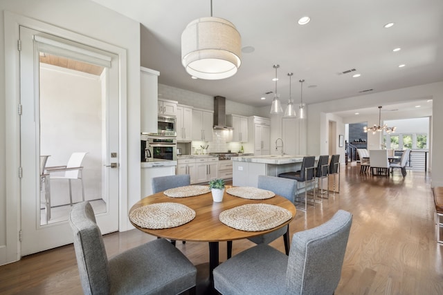 3912 Holland Ave, Dallas, TX 75219 - dining area with wood finished floors, recessed lighting, and a chandelier