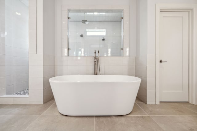 3912 Holland Ave, Dallas, TX 75219 - bathroom with tile walls, walk in shower, a soaking tub, and tile patterned floors