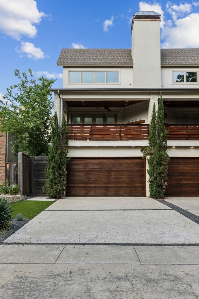 3912 Holland Ave, Dallas, TX 75219 - view of front of house featuring driveway, an attached garage, a chimney, stucco siding, and fence
